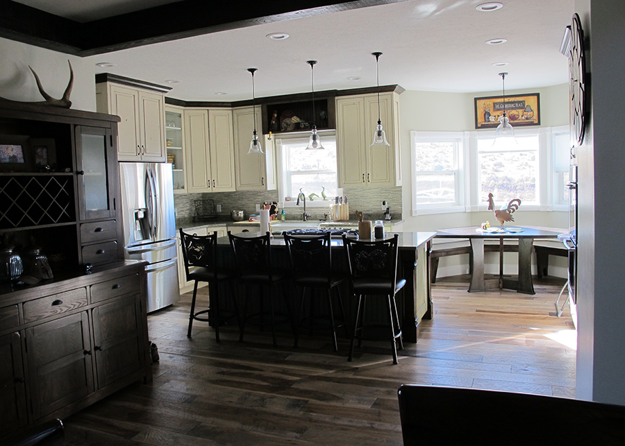 The dining room features a custom backsplash, white country cabinetry, dark wood floors, and dark wooden furniture